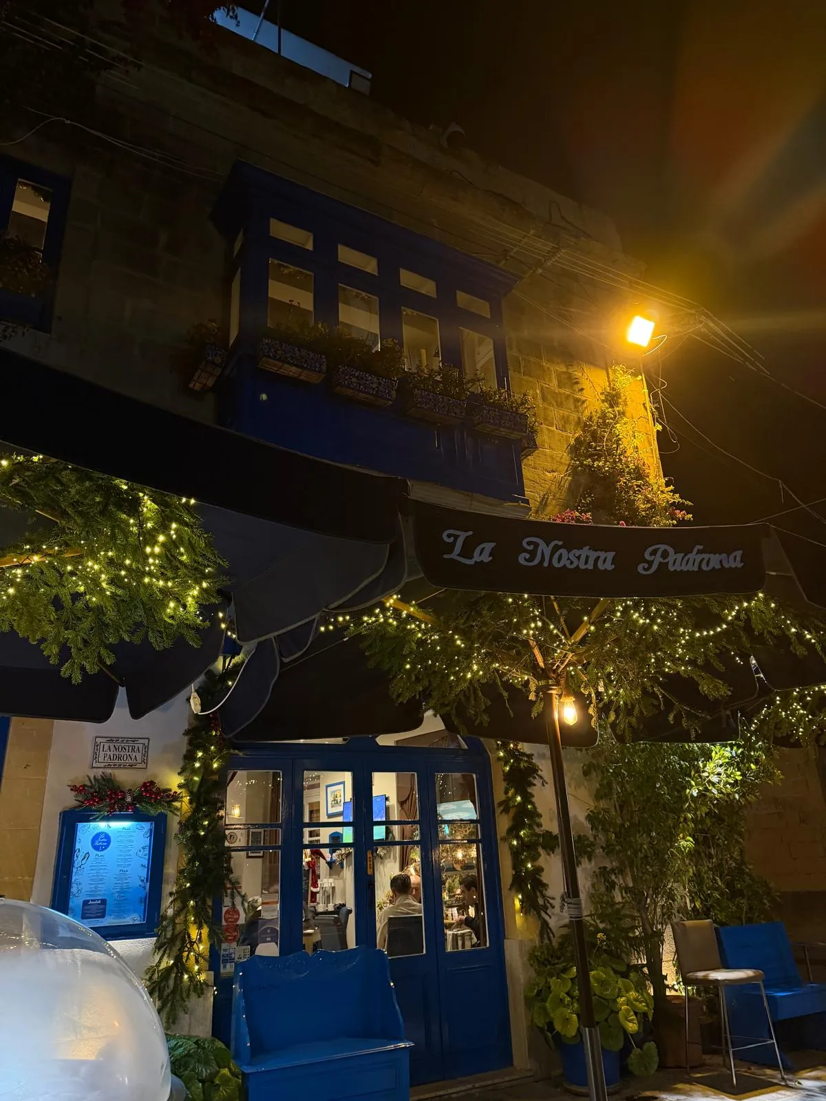 The blue doors and fairy lights of the restaurant at night