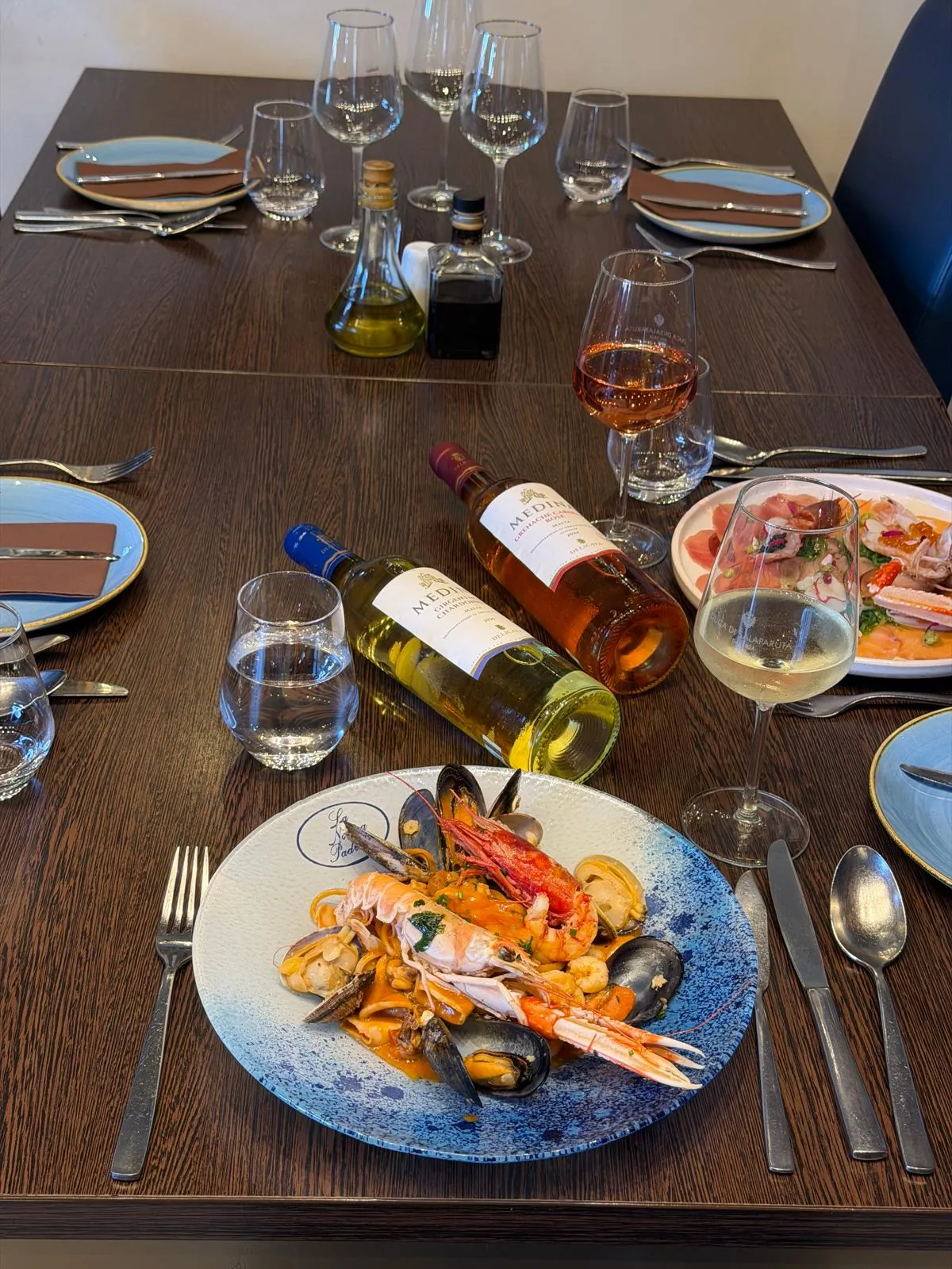 A table set with wine, glasses and seafood